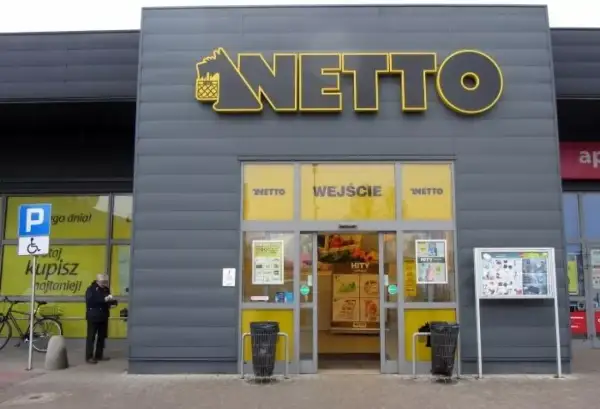 Wejście do sklepu Netto. Obok parking dla niepełnosprawnych. Aplikacja Netto pomoże Ci znaleźć najlepsze okazje.