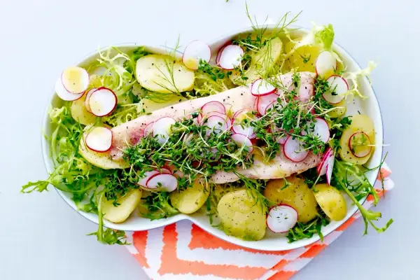 En vacker och nyttig middag med ugnsbakad fisk, färskpotatis, rädisor och krispig sallad.