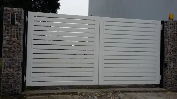 Nowoczesna, biała brama z poziomymi lamelami. Po lewej stronie widoczny enkoder, co to za urządzenie?