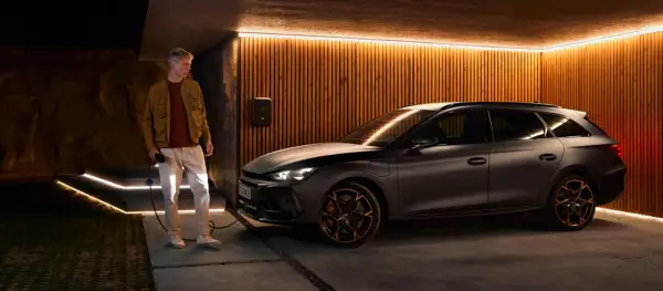 Man laddar en mörk kombi, en phev betyder att den kan köras på både el och bensin.