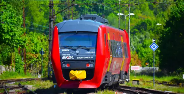 Czerwony pociąg SKPL "Marek" na torach, gotowy do podróży. Sprawdź pociąg zamość - kraków rozkład i wyrusz w drogę!