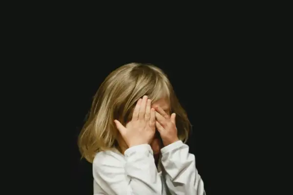 Dziecko zakrywa oczy dłońmi. Szukamy sposobów na rozładowanie emocji u dzieci, by mogły swobodnie wyrażać siebie.