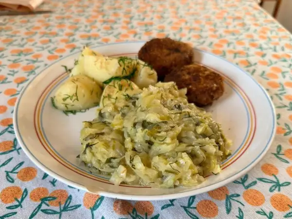 Młoda kapusta z koperkiem, przepis babci, podana z ziemniakami i kotlecikami. Pyszny, domowy obiad.