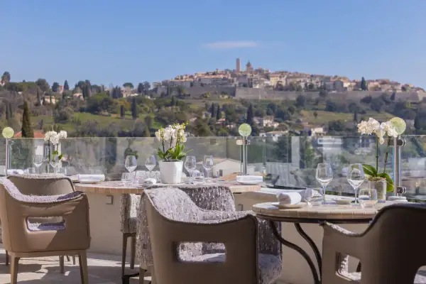Tables dressées pour un repas d'exception avec vue sur le village médiéval, typique des restaurants de Saint-Paul-de-Vence.
