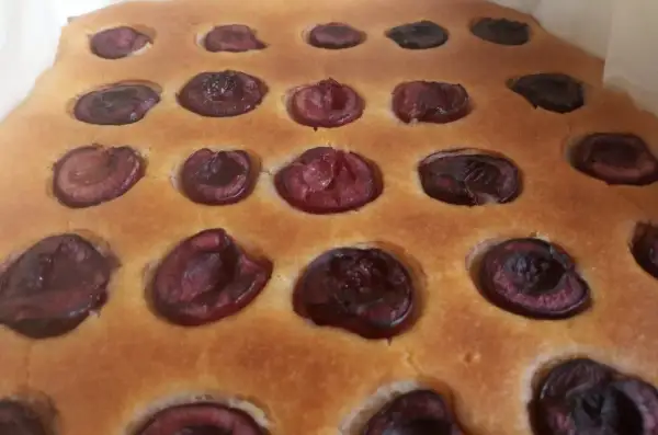 Puszyste ciasto z czereśniami, z widocznymi połówkami owoców zatopionymi w złocistym cieście. Idealne na letnie popołudnie.