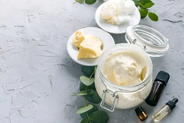 Zutaten für **Body Butter selber machen**: Kakaobutter, Sheabutter, Kokosöl und ätherische Öle. Cremige Textur in einem Glasbehälter.