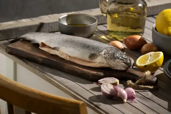 Poisson cru sur planche, citron, oignons et huile. Idéal pour enlever l'odeur de poisson maison.