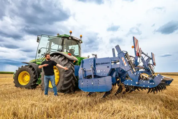 Un homme présente une charrue Rolmako, un outil agricole essentiel pour préparer les sols. La sep charrue définition est ici illustrée par cet équipement robuste.