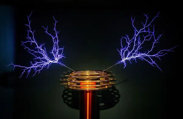 Cewka Tesli generuje fioletowe wyładowania elektryczne przypominające drzewa.