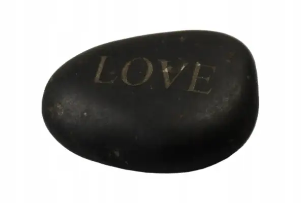 Czarny, gładki kamień z wygrawerowanym napisem "LOVE". Dałem ci kamień z wielkim love tekst, jako symbol naszej więzi.
