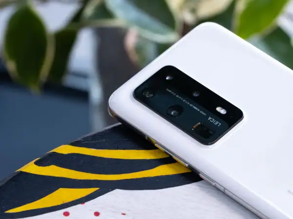 Biały smartfon z aparatem Leica na pokładzie, działający na systemie emui 10.1, leży na ozdobnej powierzchni.
