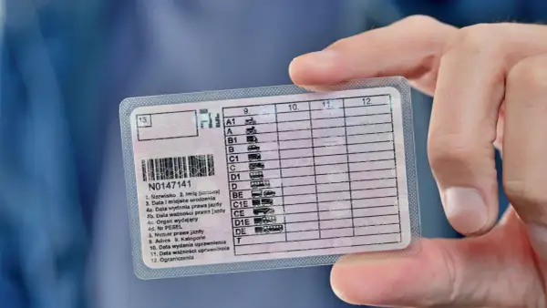 Main tenue d'un permis de conduire polonais. La question "combien de temps pour refaire un permis de conduire" est une préoccupation courante.