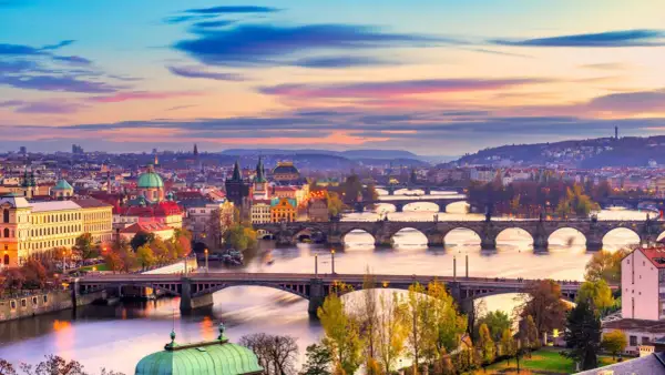 Praga o zachodzie słońca, z wieloma mostami na Wełtawie. Idealne miejsce, gdzie jechać w listopadzie, by poczuć magię miasta.