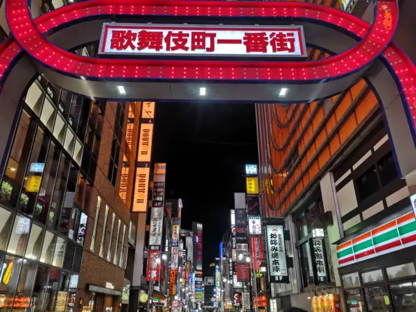Entrada al barrio rojo de Tokio, con un letrero brillante y luces rojas.