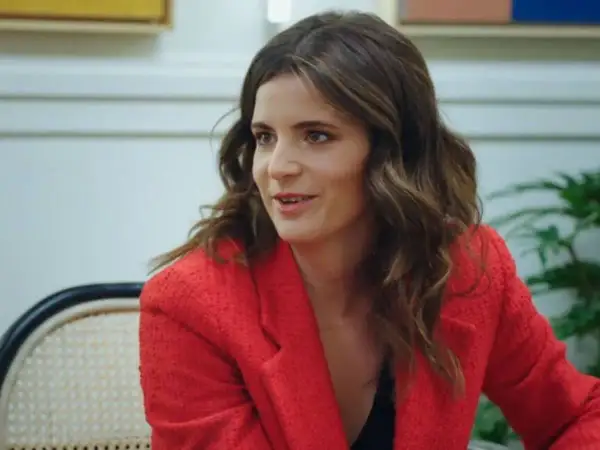 Ana Iris Simón, con su chaqueta roja, comparte ideas en una conversación animada.