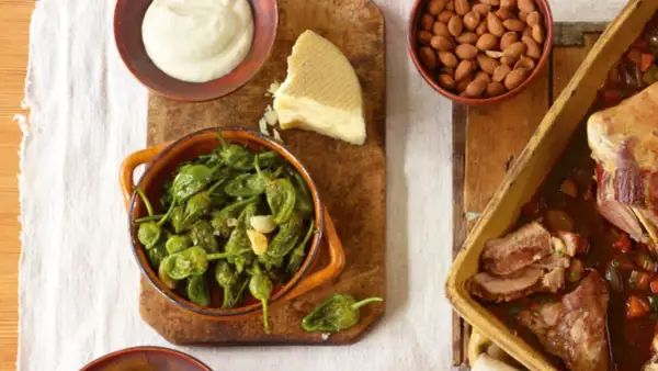 Eine **spanische Tapas Liste** mit gebratenen Pimientos, Mandeln, Käse und einem Braten.