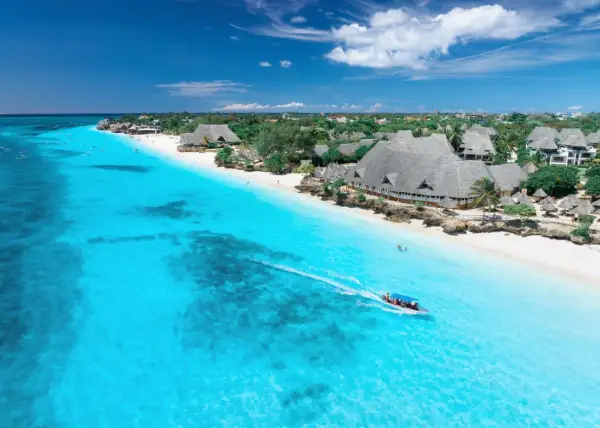 Idealny dzień, kiedy na Zanzibar. Turkusowa woda, biała plaża i łódź z turystami.