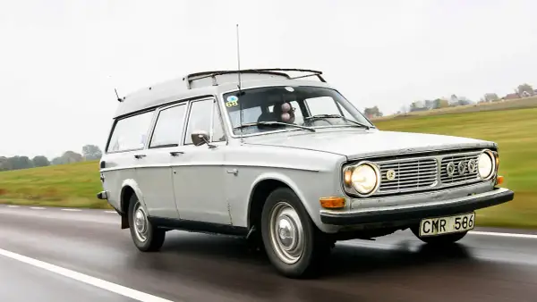 Grå Volvo 145 Express med takräcke kör på en väg.