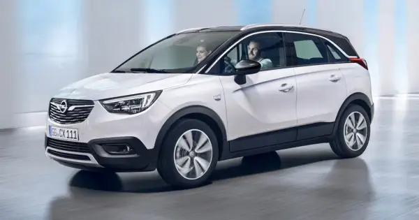 Biały Opel Crossland z parą uśmiechniętych ludzi w środku. Sprawdź atrakcyjną opel crossland cena!