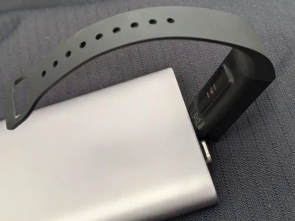 Smartband podłączony do powerbanka, pokazujący, jak ładować smartwatch bez ładowarki.