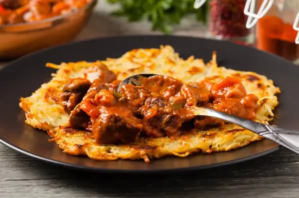 Gulasz do placka po węgiersku, bogaty i aromatyczny, podany na chrupiącym placku ziemniaczanym.
