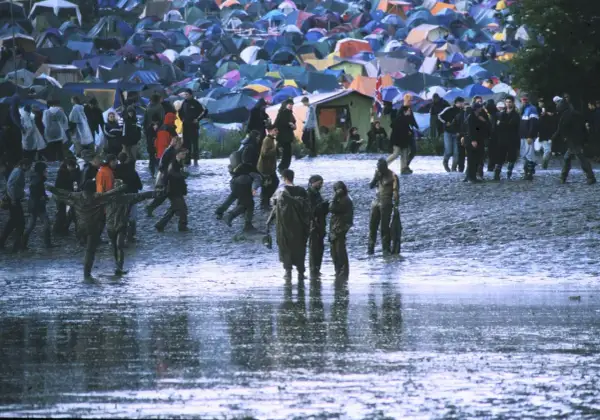 Muddy field with tents and people at Radiohead's iconic Glastonbury 1997 performance.