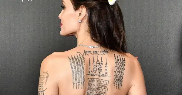 Angelina Jolie z tatuażem sak yant na plecach, przedstawiającym skomplikowane wzory i napisy.
