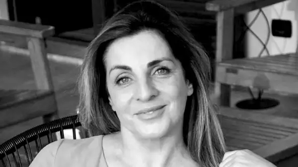 Ritratto in bianco e nero di una donna con capelli castani lunghi e mossi, occhi azzurri e un sorriso leggero. Sembra pensierosa, come se fosse andata a convivere ma non fosse felice.