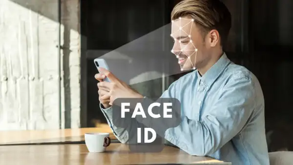 Uśmiechnięty mężczyzna korzysta z telefonu, który skanuje jego twarz. Technologia Face ID zapewnia szybki dostęp.