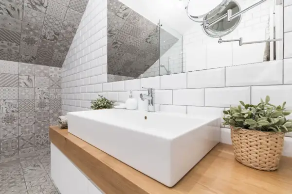 Une salle de bain moderne avec un lavabo rectangulaire blanc, des carreaux muraux blancs et des carreaux décoratifs gris. Une excellente idée carrelage petite salle de bain pour un look chic.