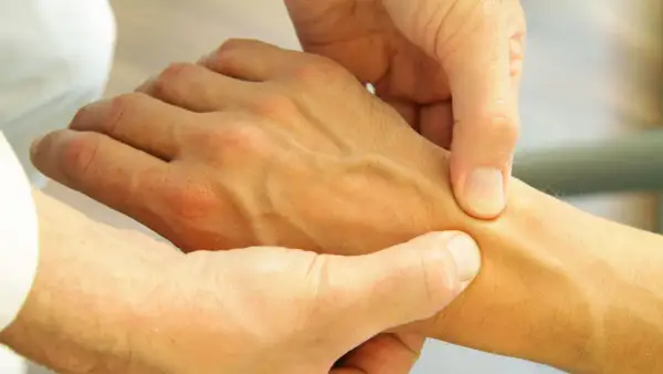 Arzt untersucht Hand, um Schmerzen in der Hand zu diagnostizieren.