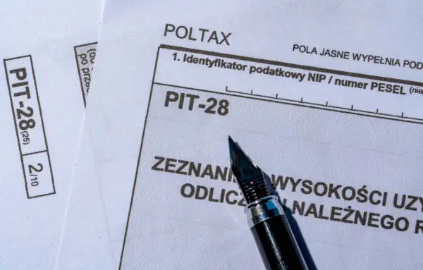 Formularz PIT-28, który służy do rozliczenia przychodów z najmu, leży obok pióra.