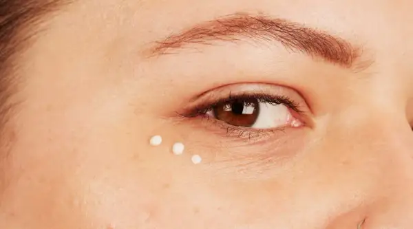 Trois petites gouttes de crème illuminent le coin de l'œil, prenant soin des yeux sensibles.