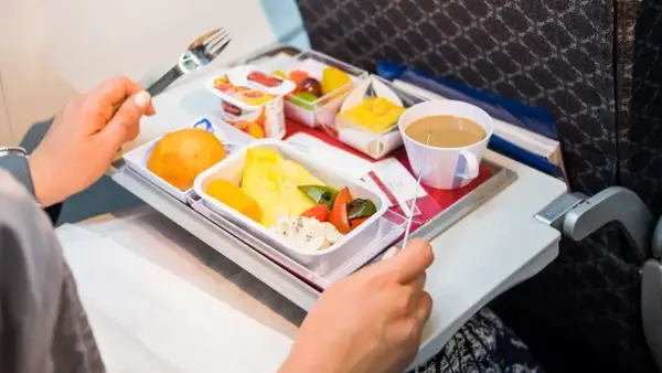 Un pasto aereo con omelette, verdure, pane e caffè. Si può portare cibo in aereo, e questo è un esempio di come viene servito.