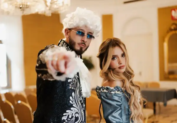 Para z epoki, on w peruce i okularach, ona w błękitnej sukni. Ich styl to akcent mandacik tekst.