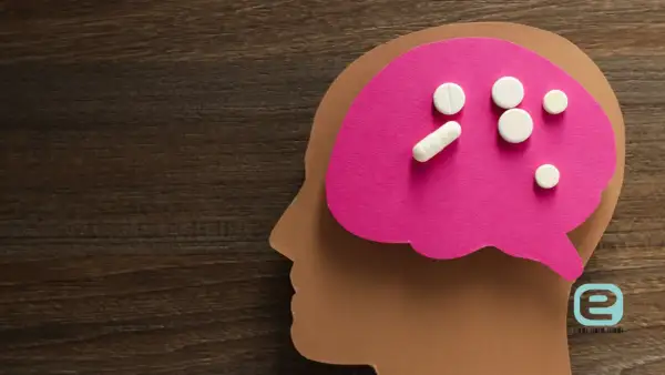 Pigułki na różowym tle symbolizującym mózg, sugerujące zespół serotoninowy objawy i leczenie.