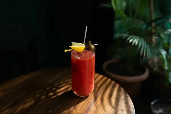 Kieliszek Bloody Mary z cytryną i oliwką. Ciekawa bloody mary historia tego drinka zaczyna się w latach 20. XX wieku.