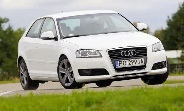 Białe Audi A3 8P w ruchu, z widoczną żarówką stopu.