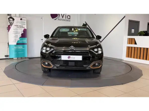 Une voiture noire sur un plateau tournant, prête pour un dépôt vente véhicule. Le logo Via Automobile est visible.
