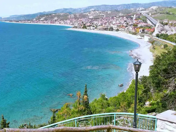 Vista panoramica delle spiagge di Reggio Calabria, con il mare cristallino che lambisce la costa e il borgo arroccato sulle colline.