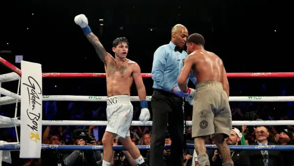 Boxer with arm raised, referee between two fighters. A majority decision in boxing means two of the three judges scored the fight for one boxer.