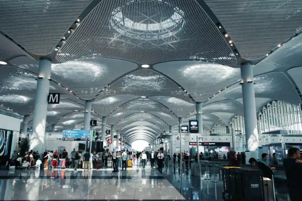 Nowoczesny terminal lotniska z ludźmi i bagażami. Zastanawiasz się, ile wcześnie być na lotnisku? Tutaj jest tłoczno.