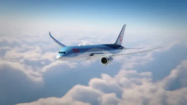 Ett TUI-flygplan flyger över molnen, perfekt för din flyg till Thailand tid.