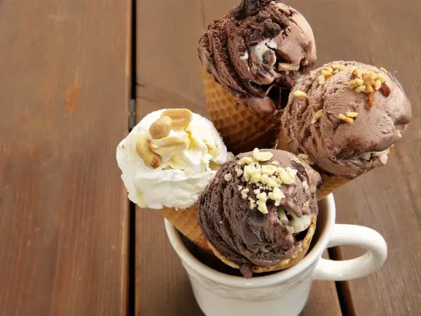 Cuatro helados en conos, dos de chocolate y uno blanco con cacahuates, perfectos como helados para diabéticos tipo 2.