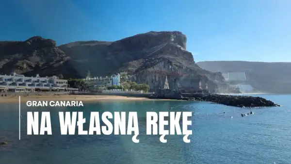 Gran Canaria zwiedzanie: malownicza plaża z hotelami i klifami w tle, błękitne morze.