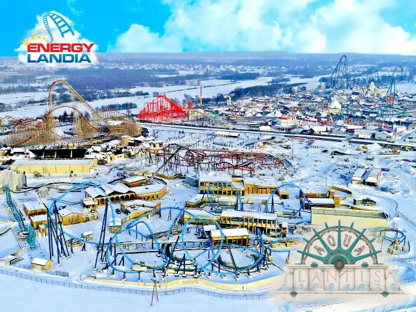 Zimowy krajobraz Energylandii z kolejkami górskimi i budynkami. To miejsce oferuje multisportowe atrakcje przez cały rok.