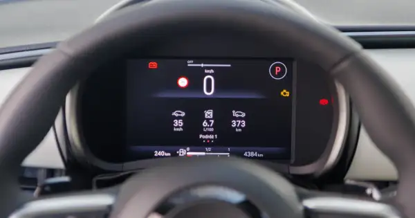 Cyfrowy kokpit pokazuje prędkość 0 km/h, średnie spalanie 6.7 L/100km i dystans 373 km. To pomocne informacje, jak obliczyć spalanie.