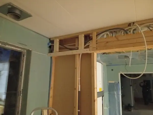 Pågående renovering av badrum med synliga rör och trästomme.