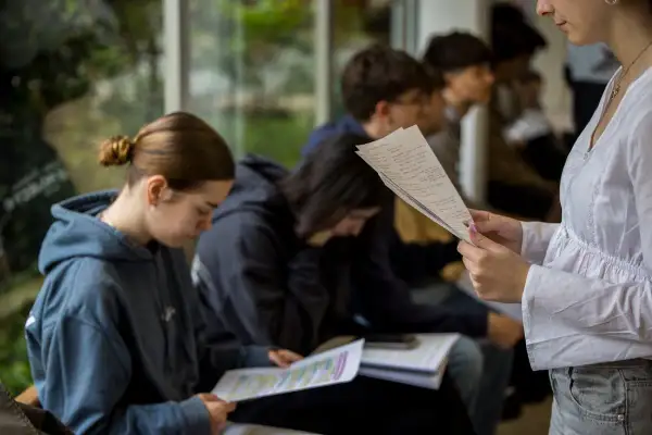 Estudiantes concentrados en sus apuntes, explorando las ventajas de estudiar en el extranjero y descubriendo nuevas oportunidades.