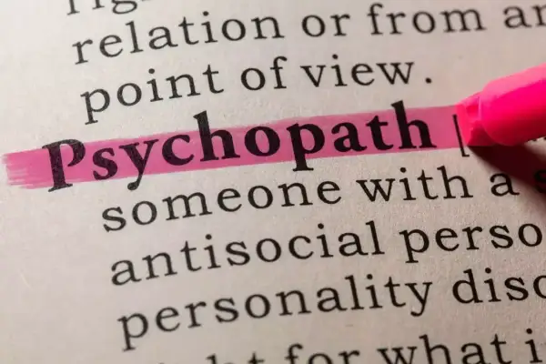 Słowo "psychopata" podkreślone różowym zakreślaczem w słowniku. Opisuje osobę z antyspołecznym zaburzeniem osobowości.